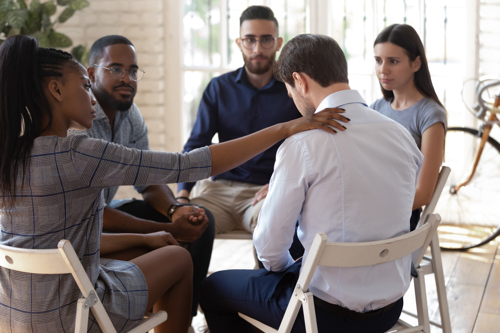 Group of people helping out depressed man