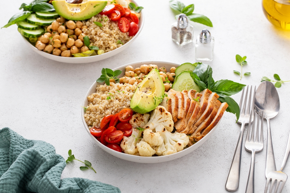 Healthy high protein lunch bowl with grilled chicken, roasted cauliflower, herbed chickpeas and quinoa