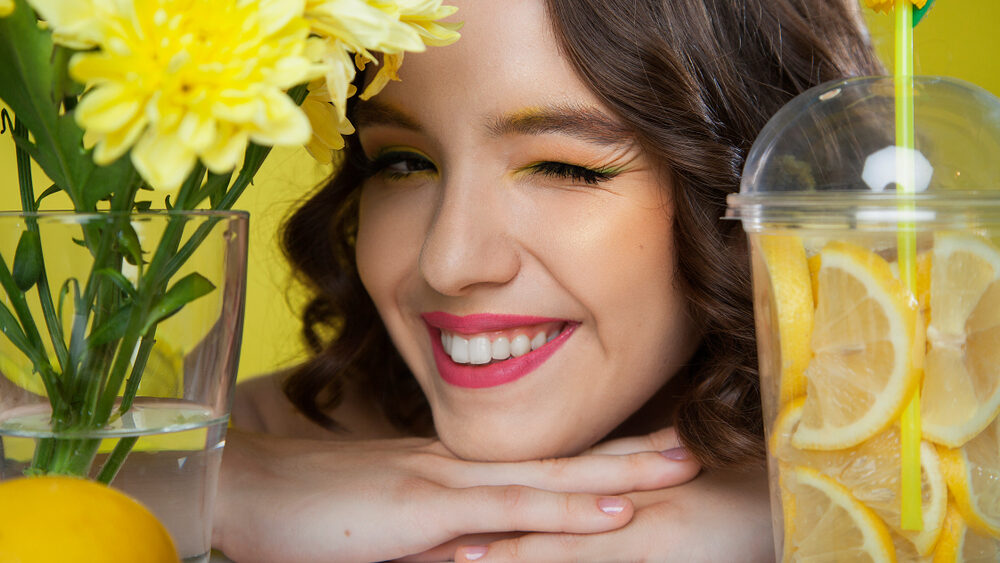 a girl with a lemon drink representing healthy skin by lemon