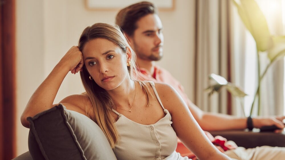 A couple in tension sitting on the couch in a tense situation