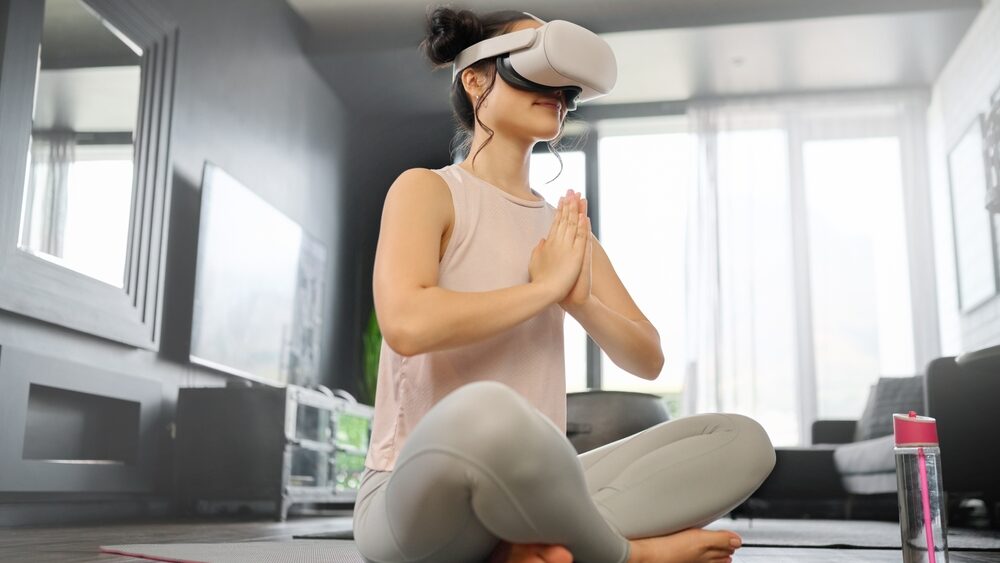 VR, meditation and fitness with a woman using a headset to access the metaverse in her home for health. Virtual reality, yoga and exercise with a young female yogi meditating in her house using 3d ai
